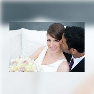 bride smiling with groom kissing cheek